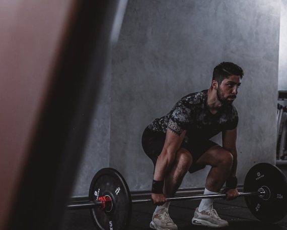 Man lifting weights in gym, displaying strength and focus. Ideal for fitness and training themes.